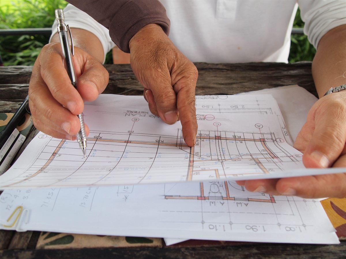 Contractor marking up a set of construction drawings on site